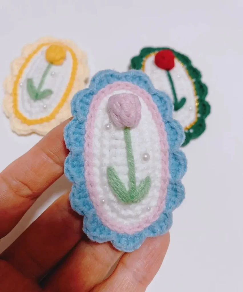 Crocheted flower brooch, light blue, pink, white.