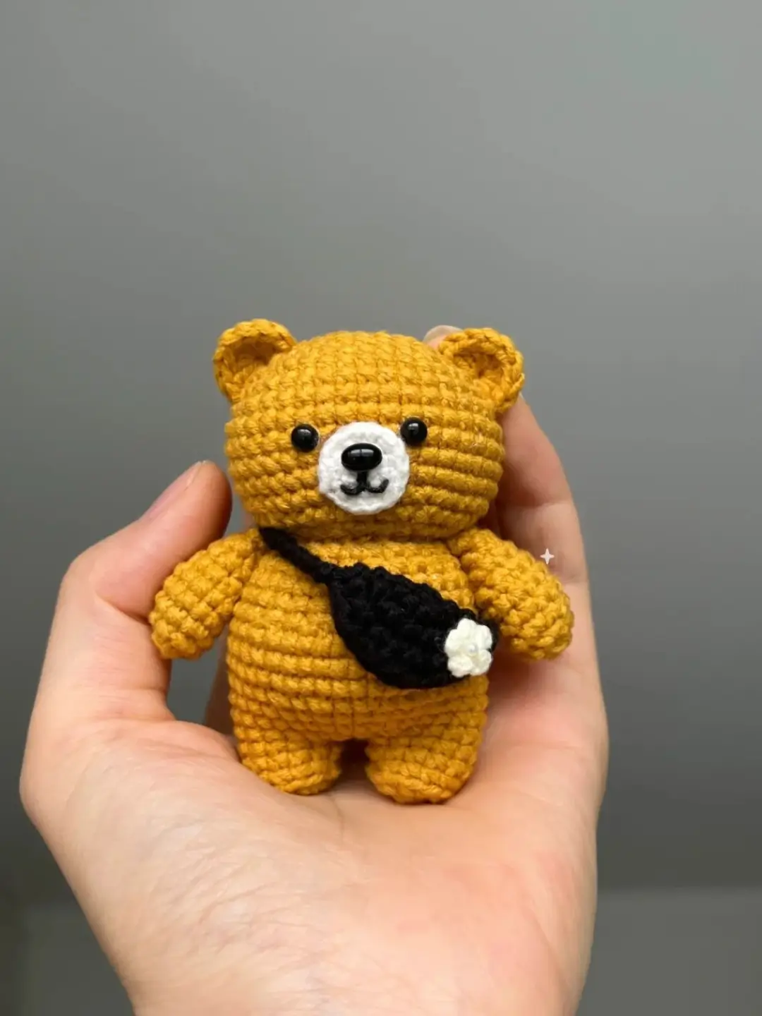 Small crocheted yellow bear with black purse.