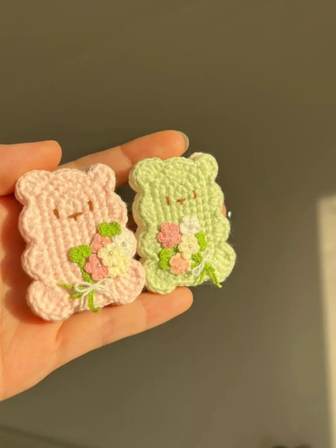 Crocheted bear charms, light pink and light green, flowers.