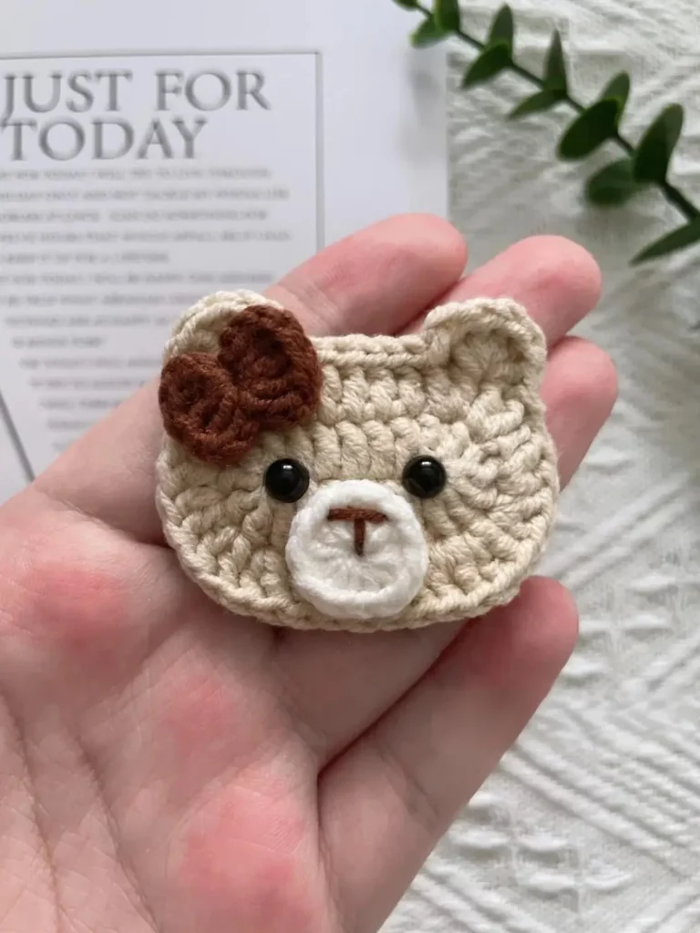 Crochet bear face, beige, brown bow.