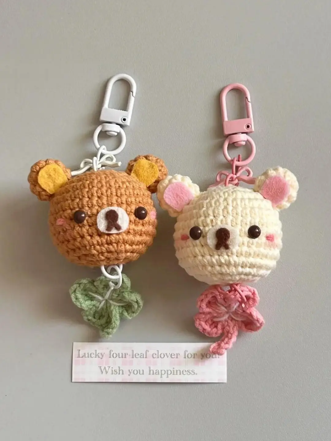 Two crocheted bear keychains,  lucky four-leaf clover.