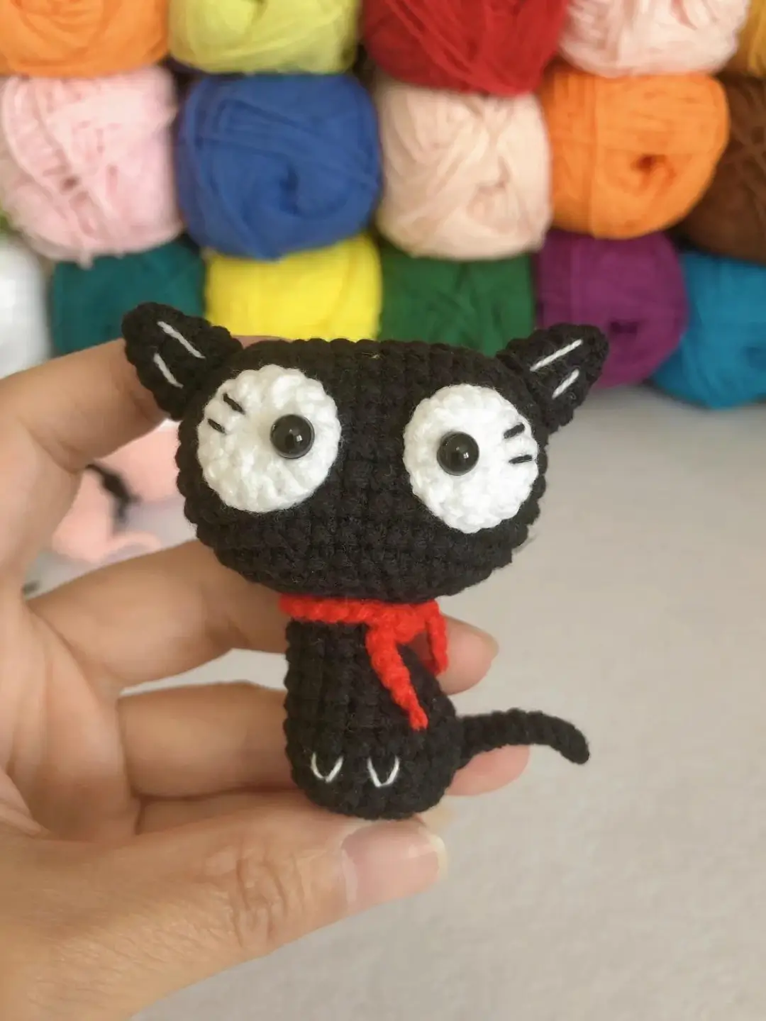 Crocheted black cat with red scarf.  Cute amigurumi.
