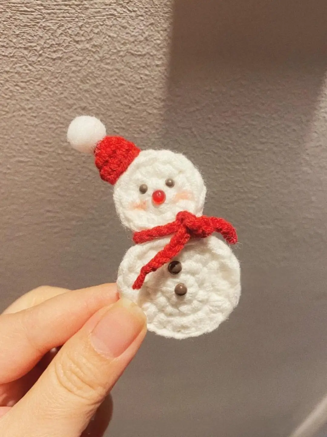 Crocheted snowman ornament, red hat, scarf.