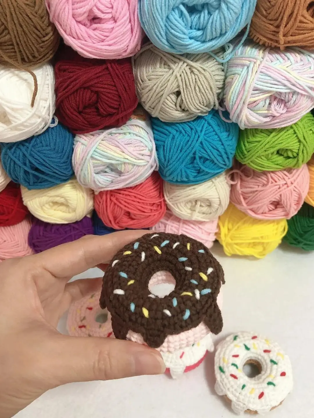 Crocheted donut, colorful yarn background.
