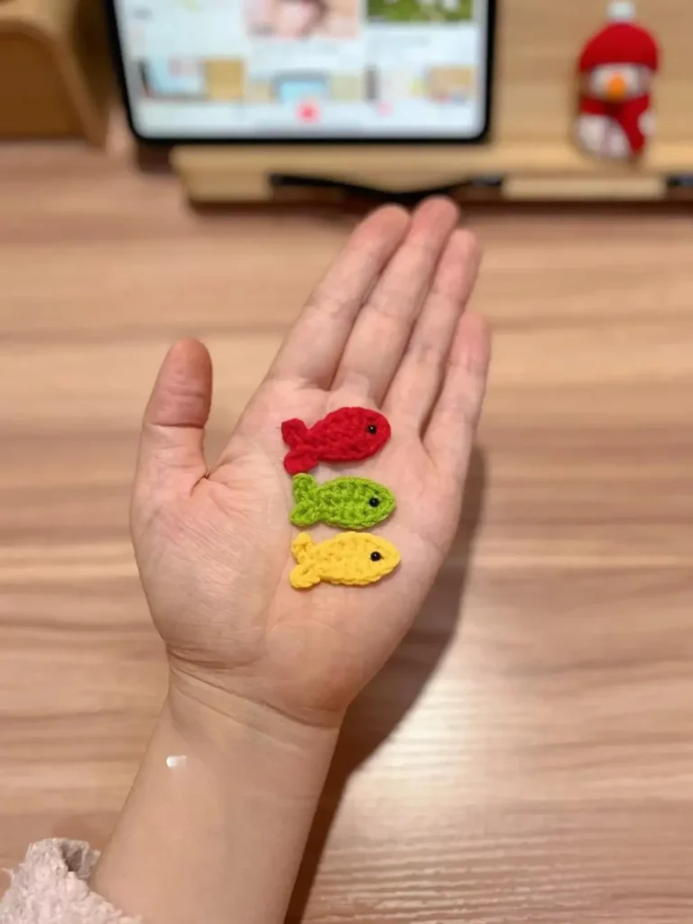 Crocheted fish, red, green, yellow.