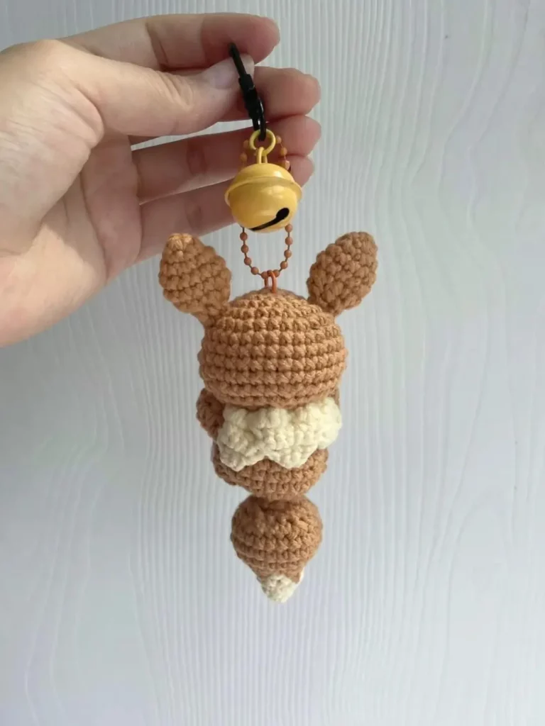 Crochet Eevee keychain, tan and cream colors, bell.