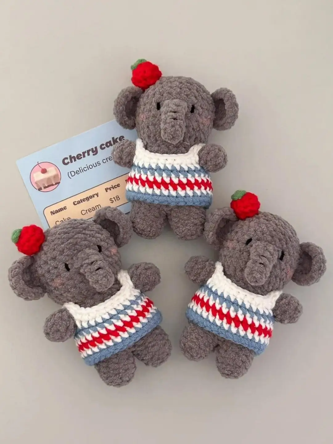 Adorable gray crochet elephant toys,  cherry cake themed.
