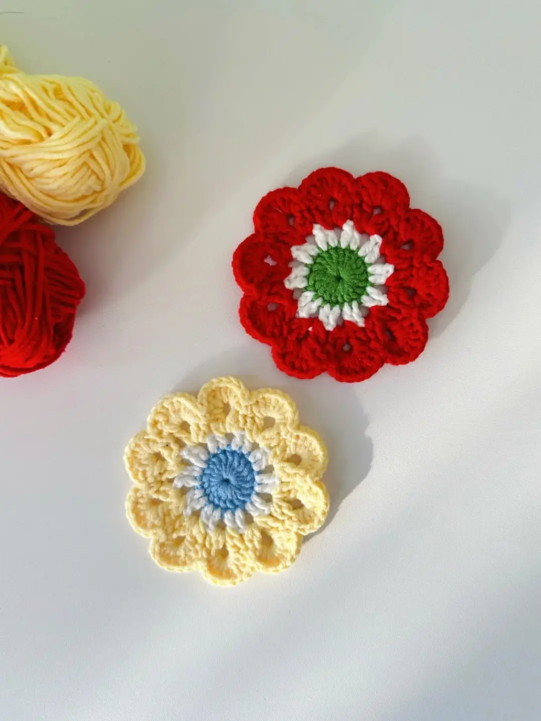 Crocheted flower coasters, red and yellow.