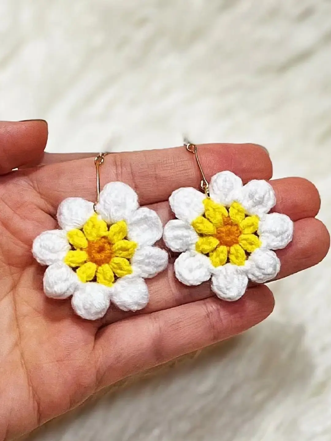 Crocheted daisy flower earrings, white with yellow centers.