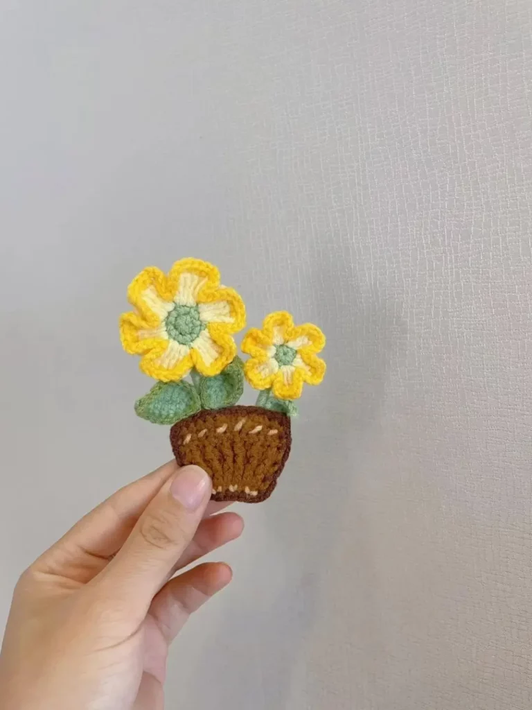 Crocheted flower pot with yellow flowers.  Small craft project.