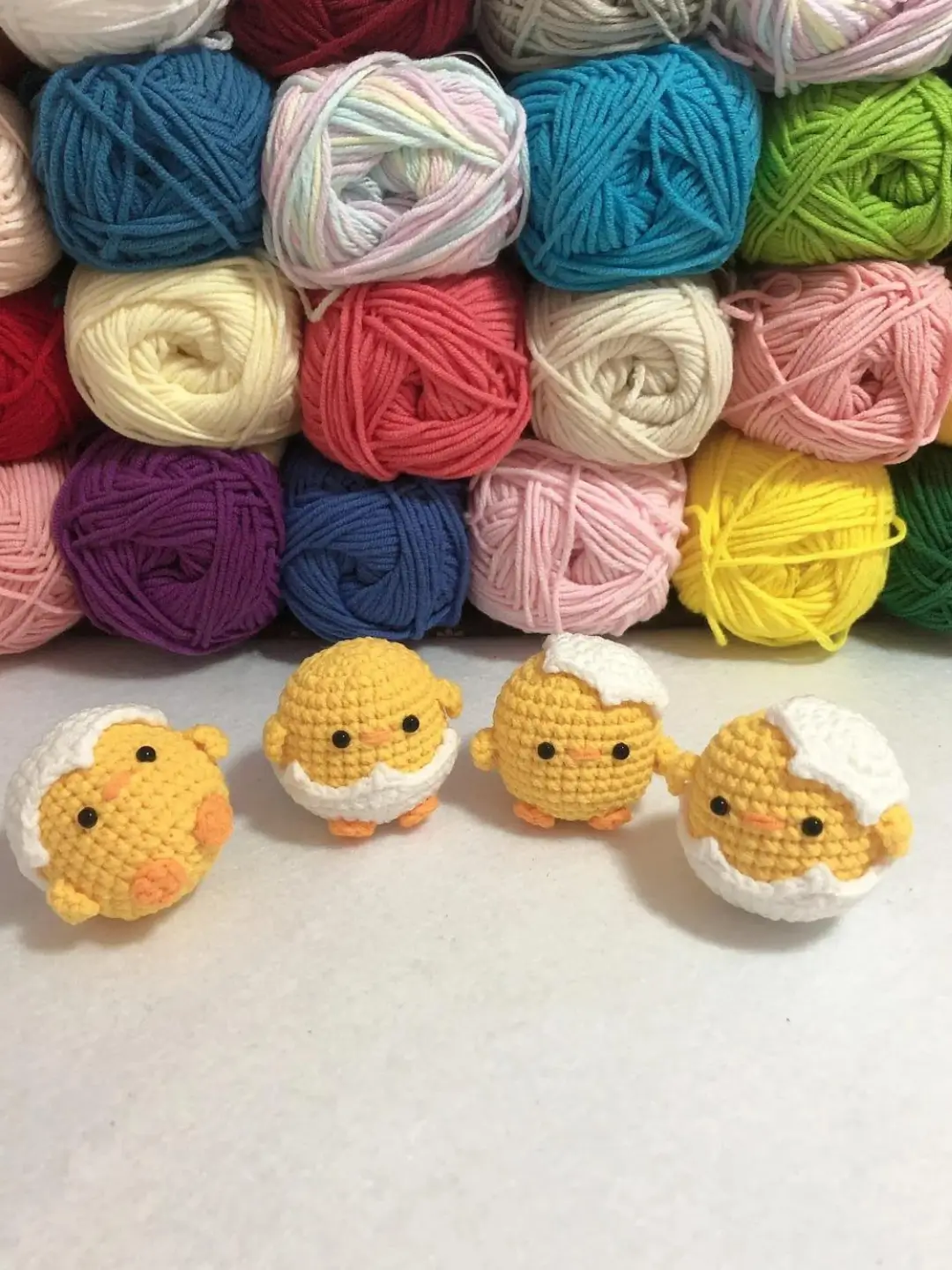 Crocheted chicks, yarn balls, colorful yarn.