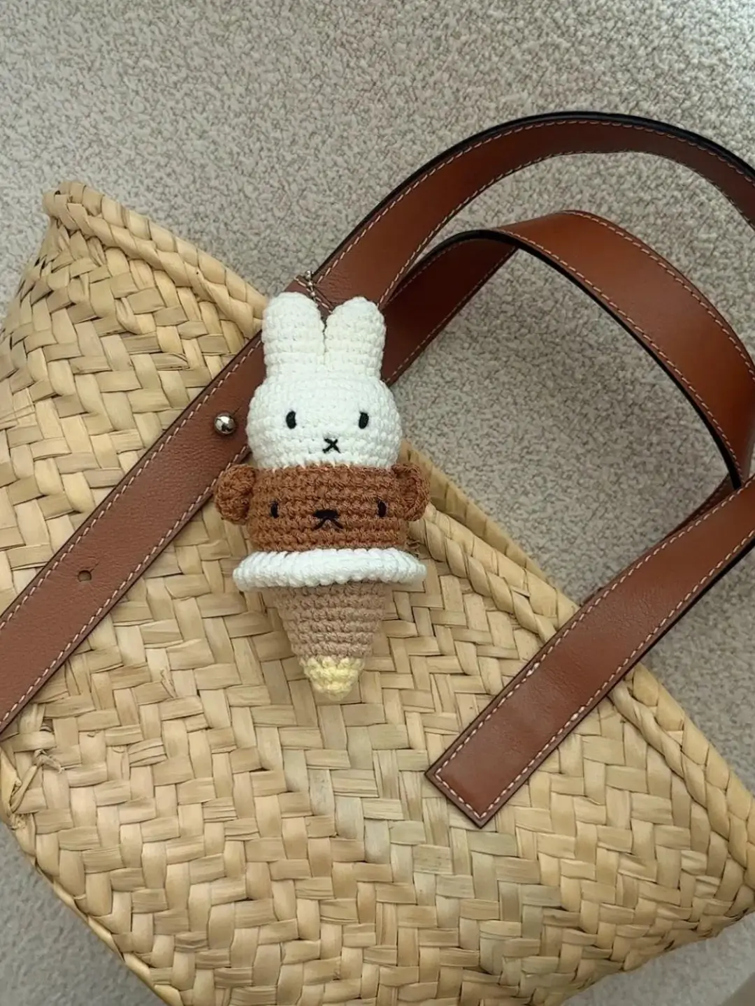 Cream & brown crochet bunny ice cream charm on woven straw bag.