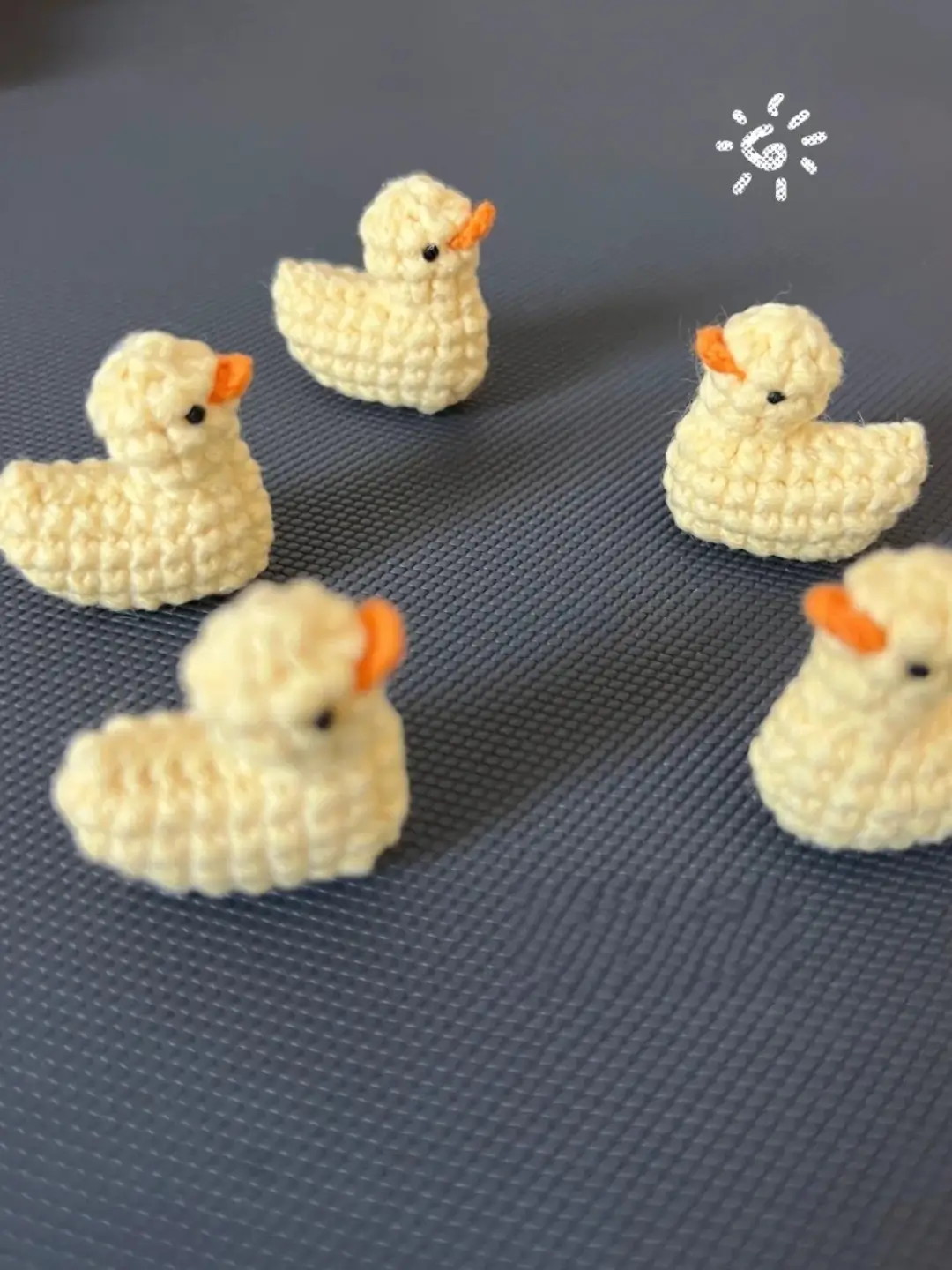 Four small crocheted yellow ducklings.