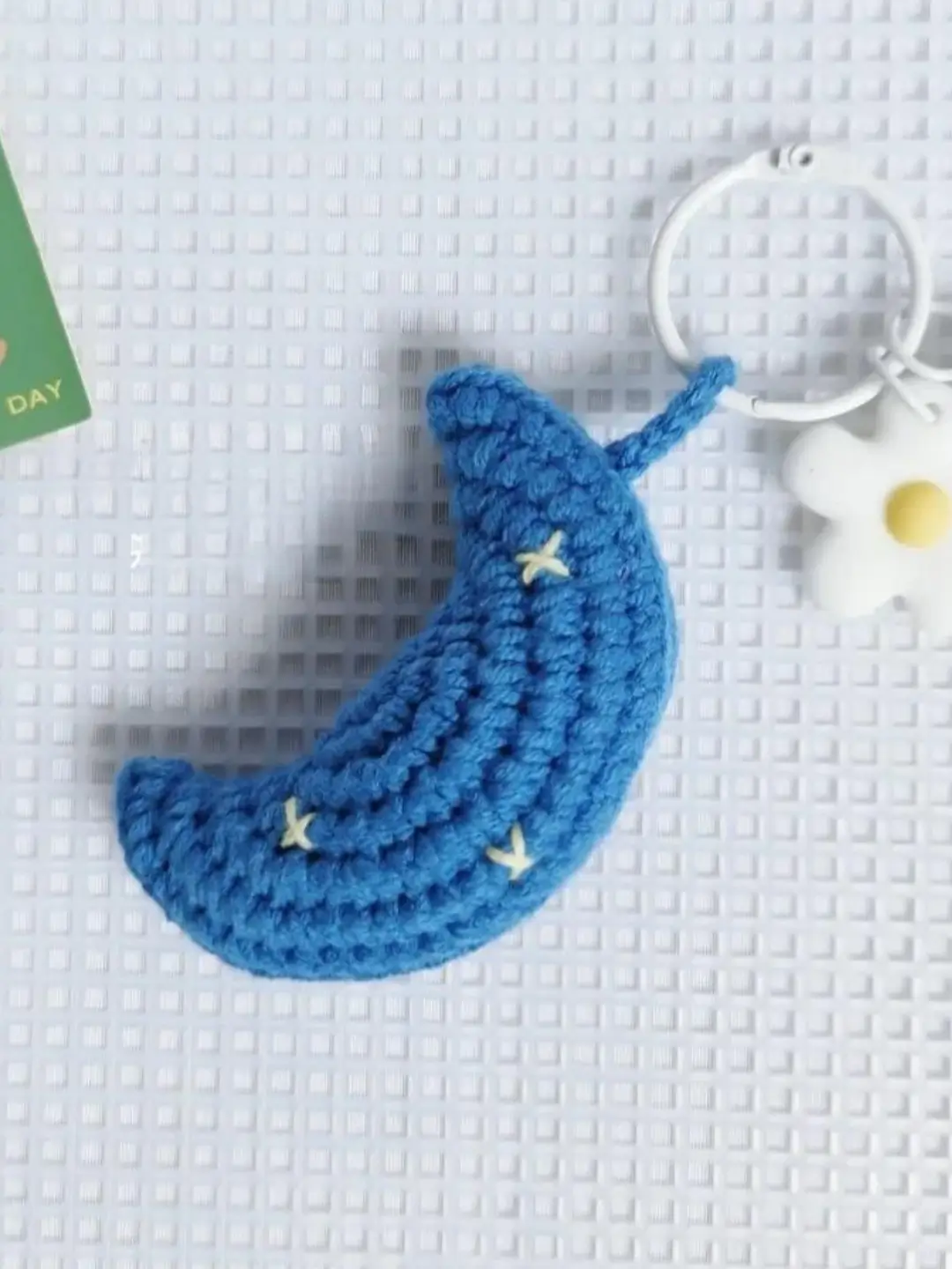 Crocheted blue crescent moon keychain.
