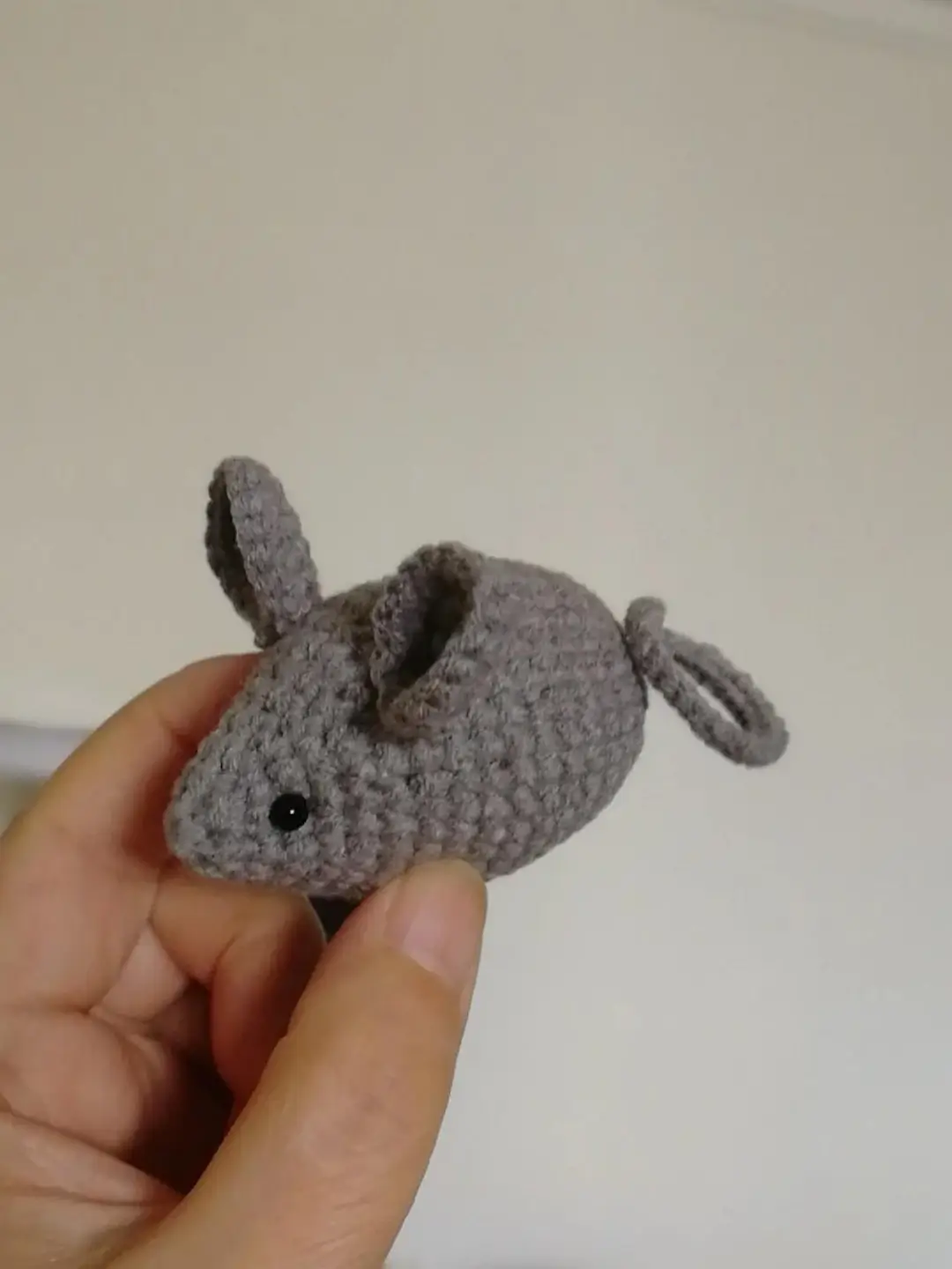 Grey crocheted mouse toy.