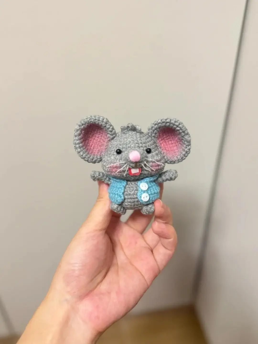 Crochet mouse toy, gray, light blue vest, pink ears.