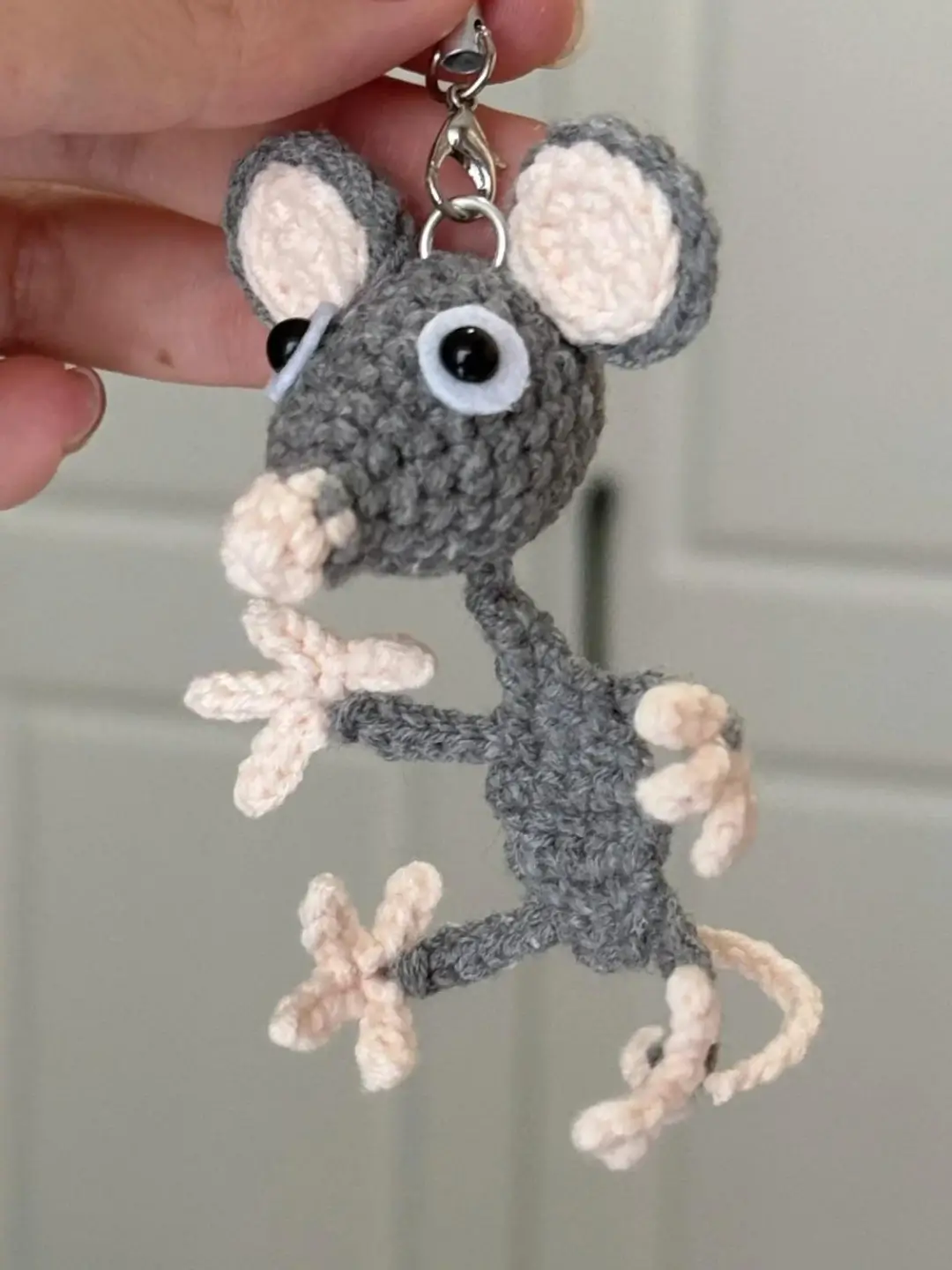 Crochet mouse keychain, gray, pink details.
