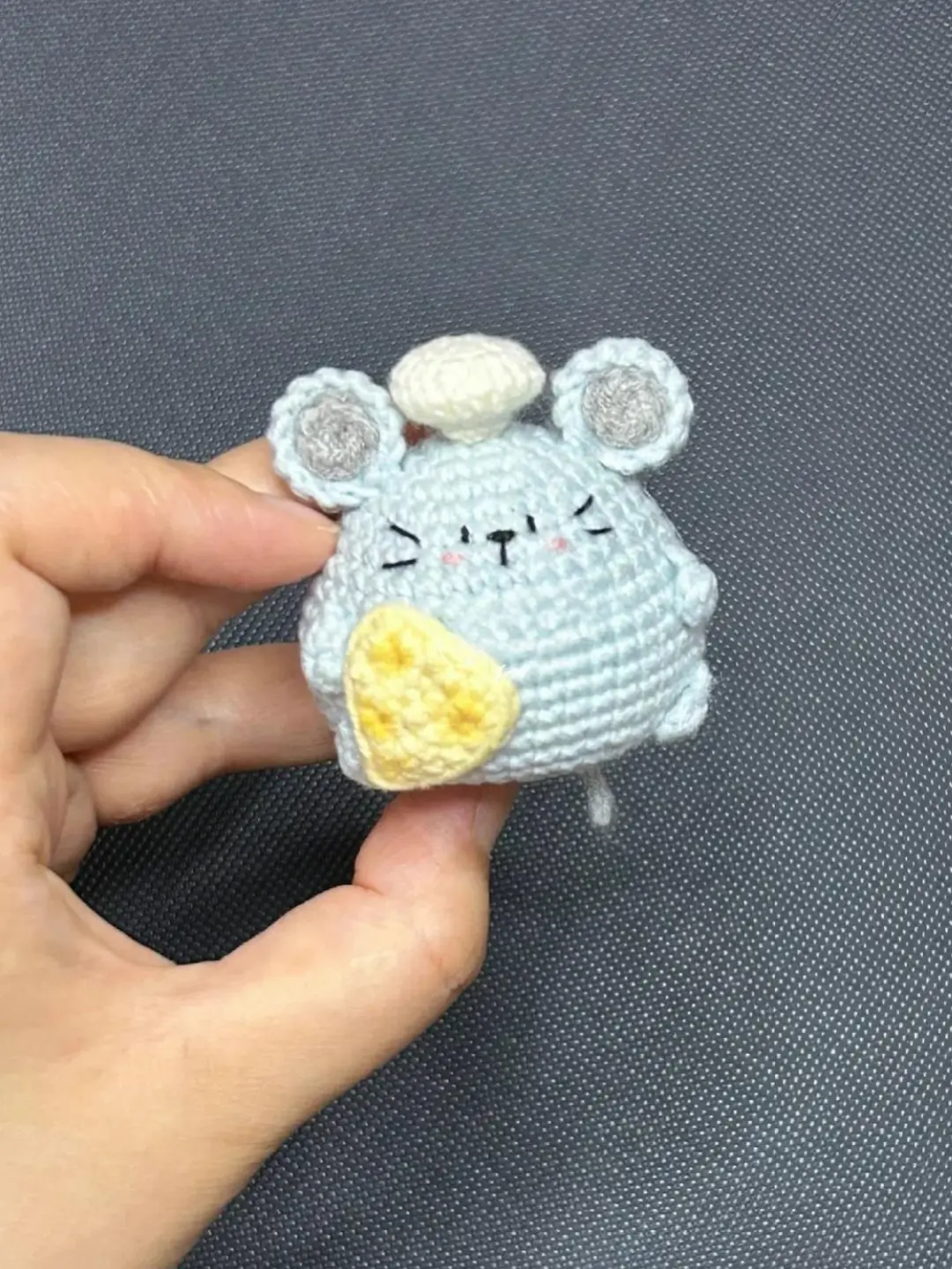 Cute light blue amigurumi mouse with chef's hat and cheese.