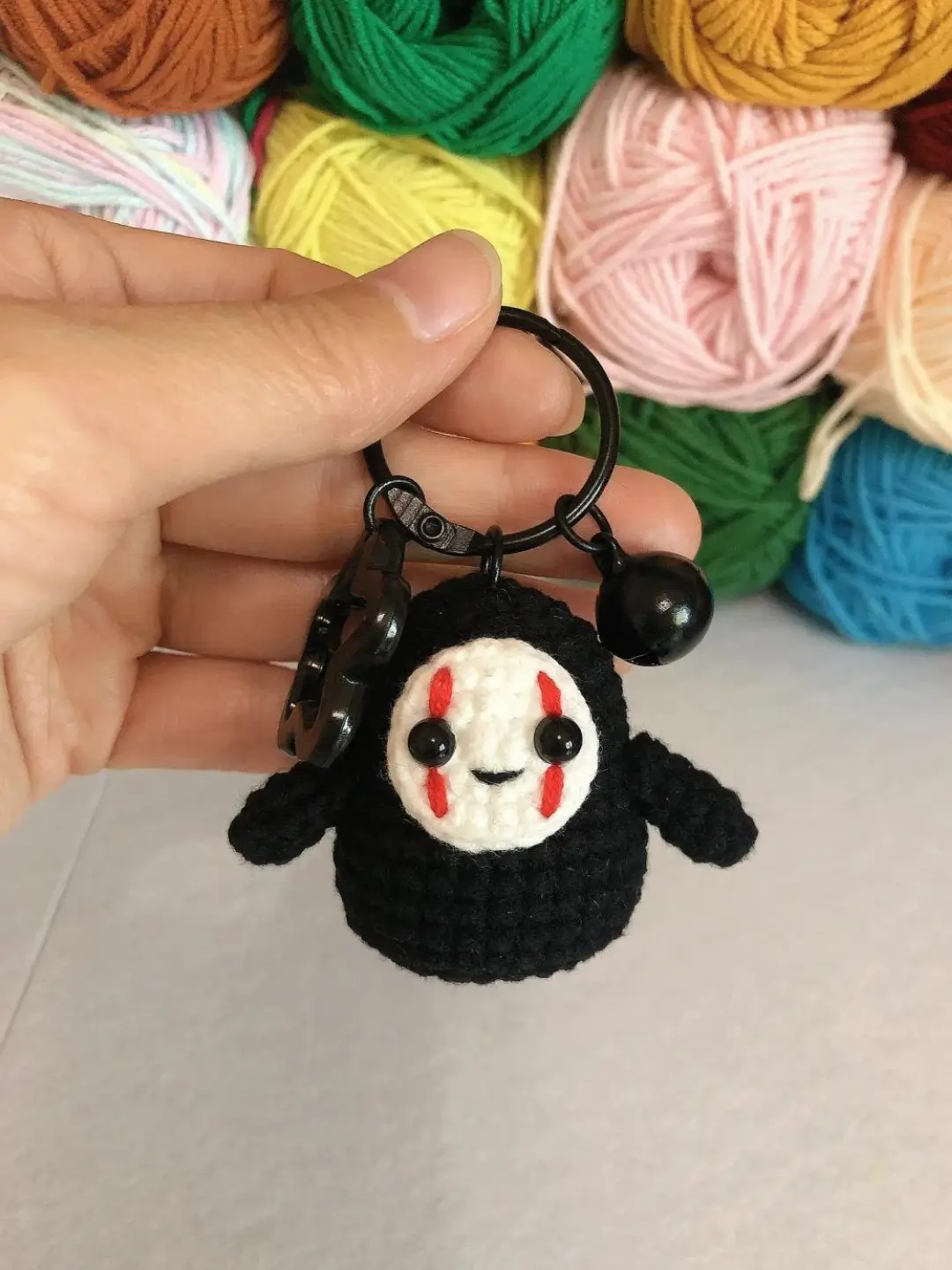 Crochet No Face keychain, black, red details.