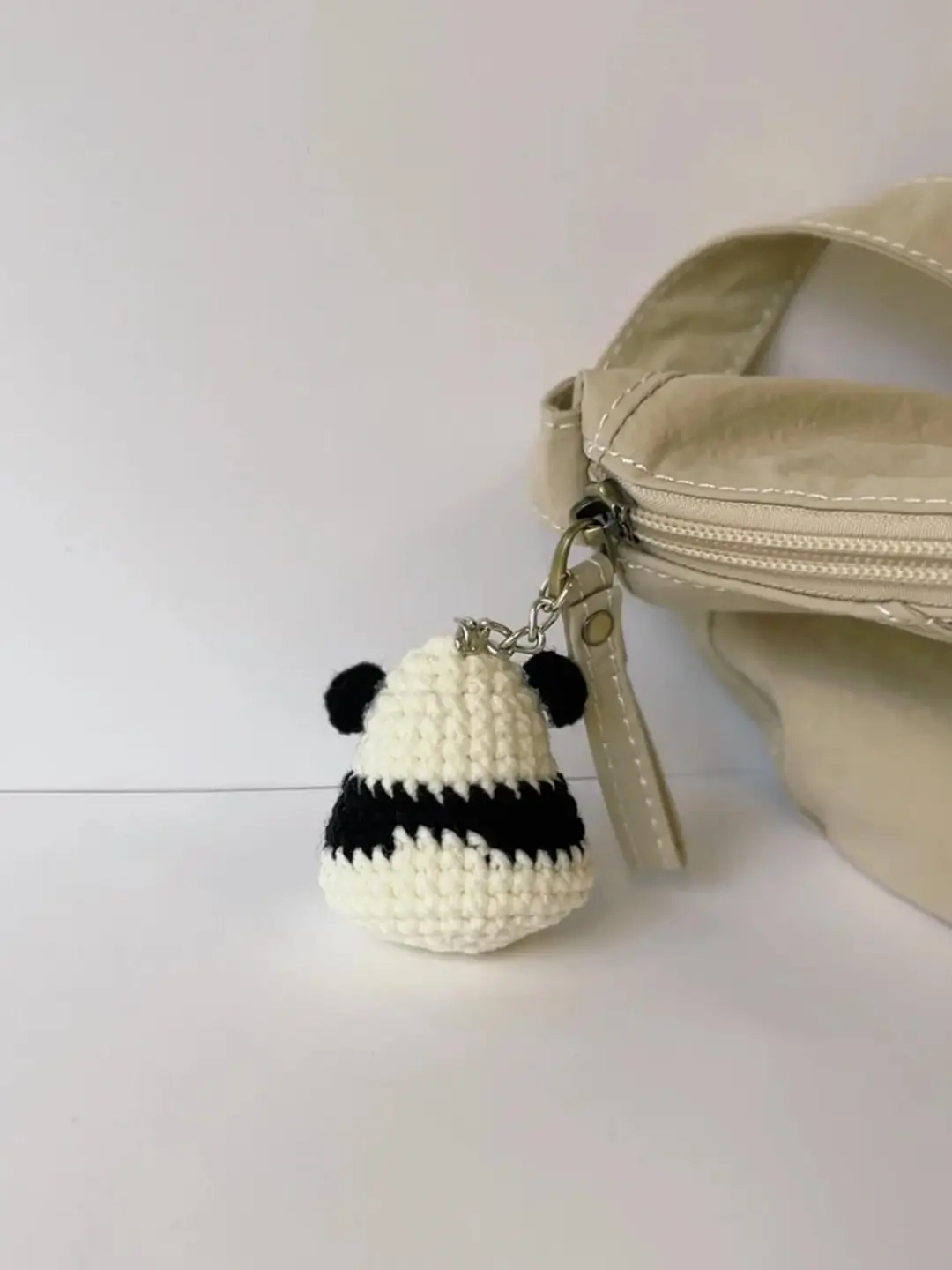 Crochet panda keychain, beige bag.