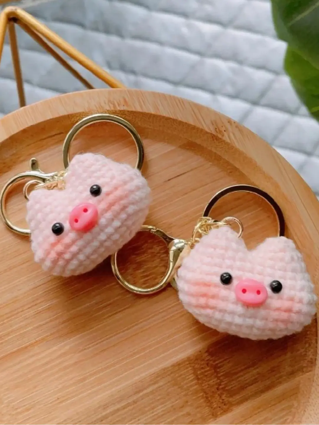 Two crocheted pink pig keychains.
