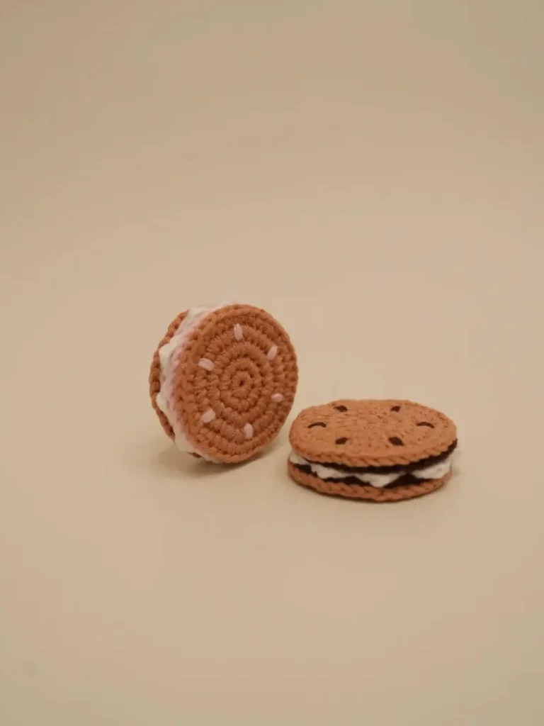 Crocheted sandwich cookies, one vanilla, one chocolate chip.