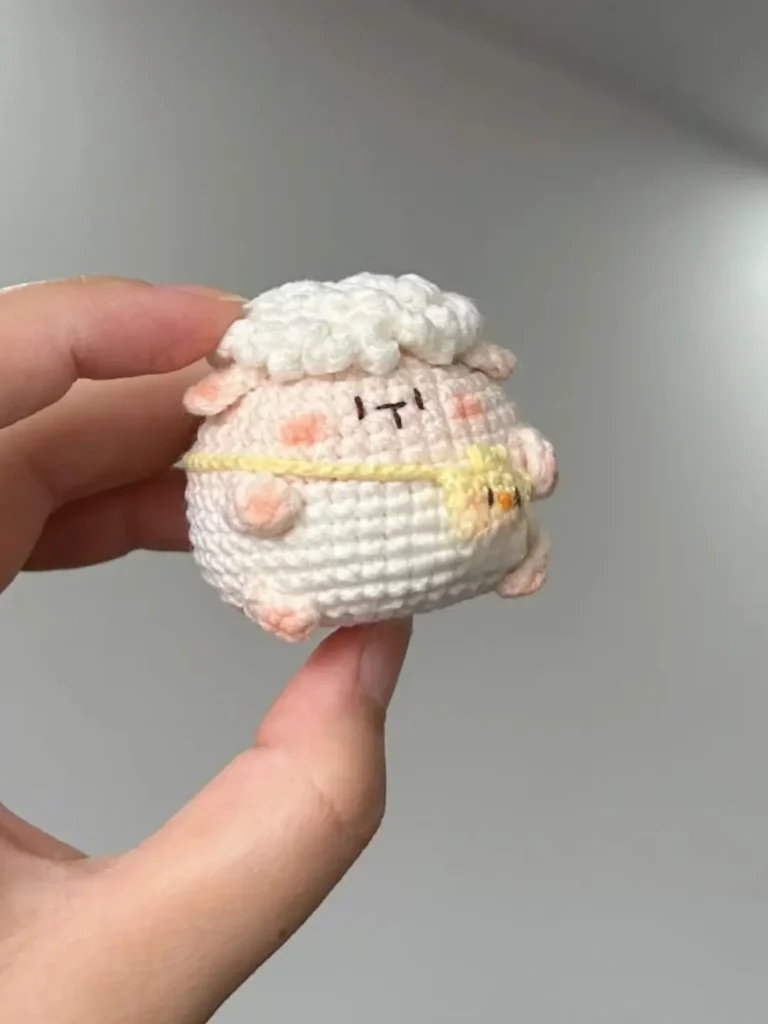Crocheted sheep figurine, light pink and white.