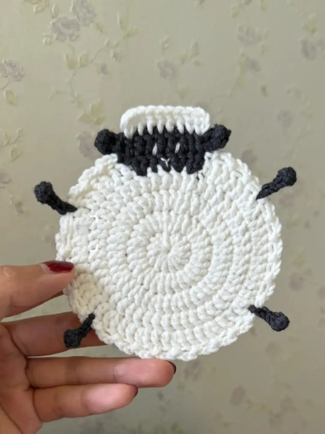 Crochet sheep coaster, white and dark gray.