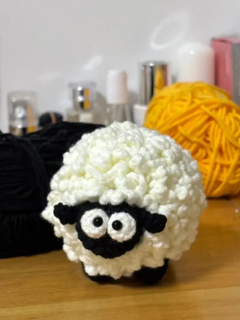 Crocheted sheep, white fluffy, black face.
