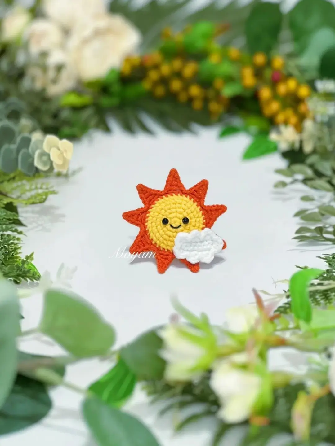 Crocheted sun with cloud, orange and yellow.