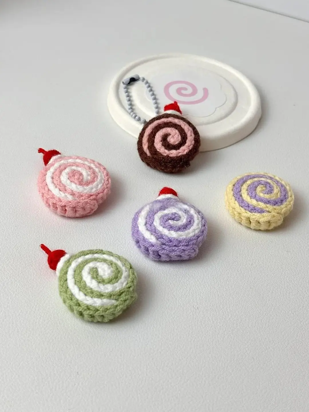 Crocheted swirl pastries, colorful  keychain charms.
