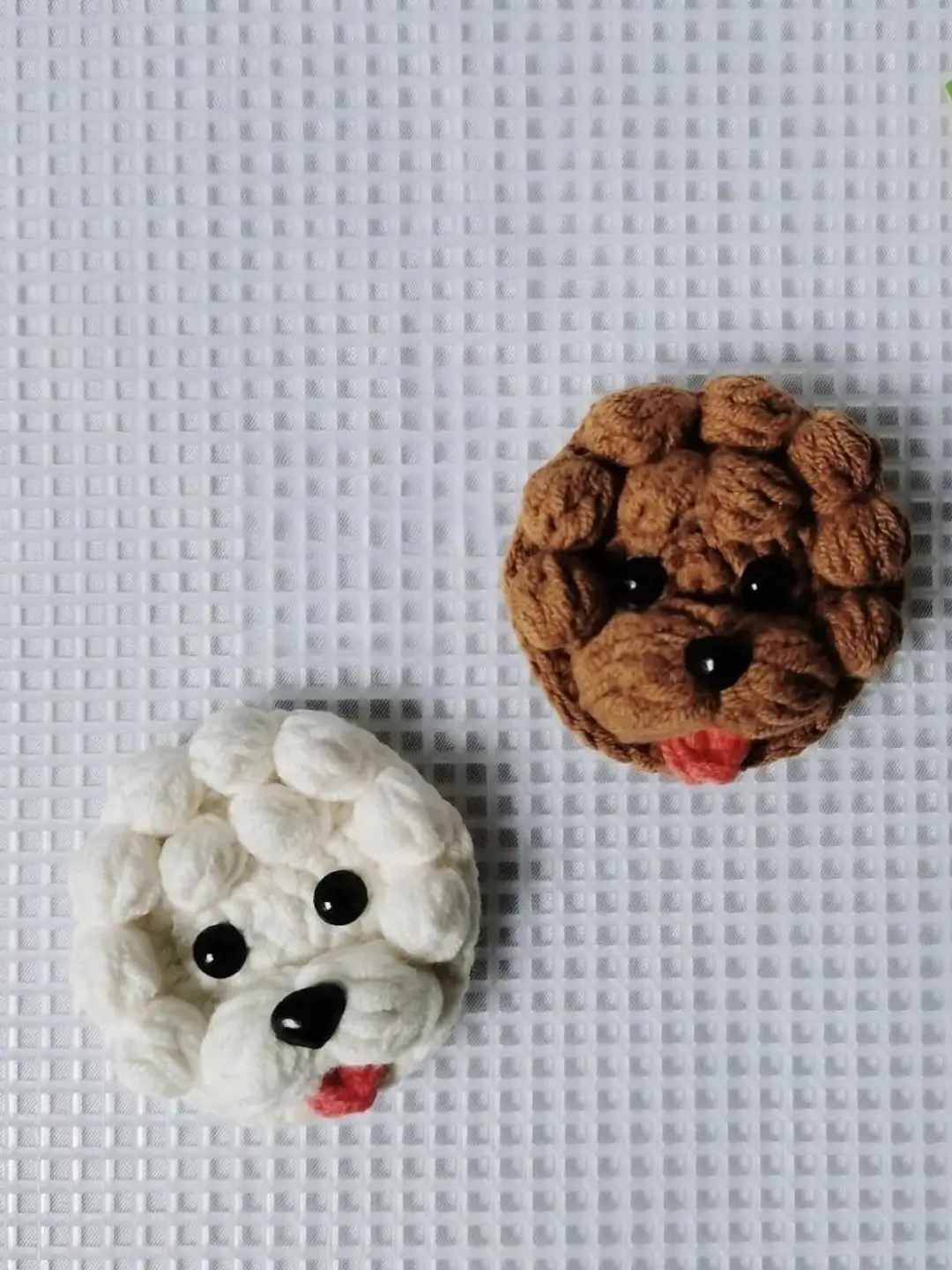 Crocheted dog faces, white and brown.  Handmade amigurumi.