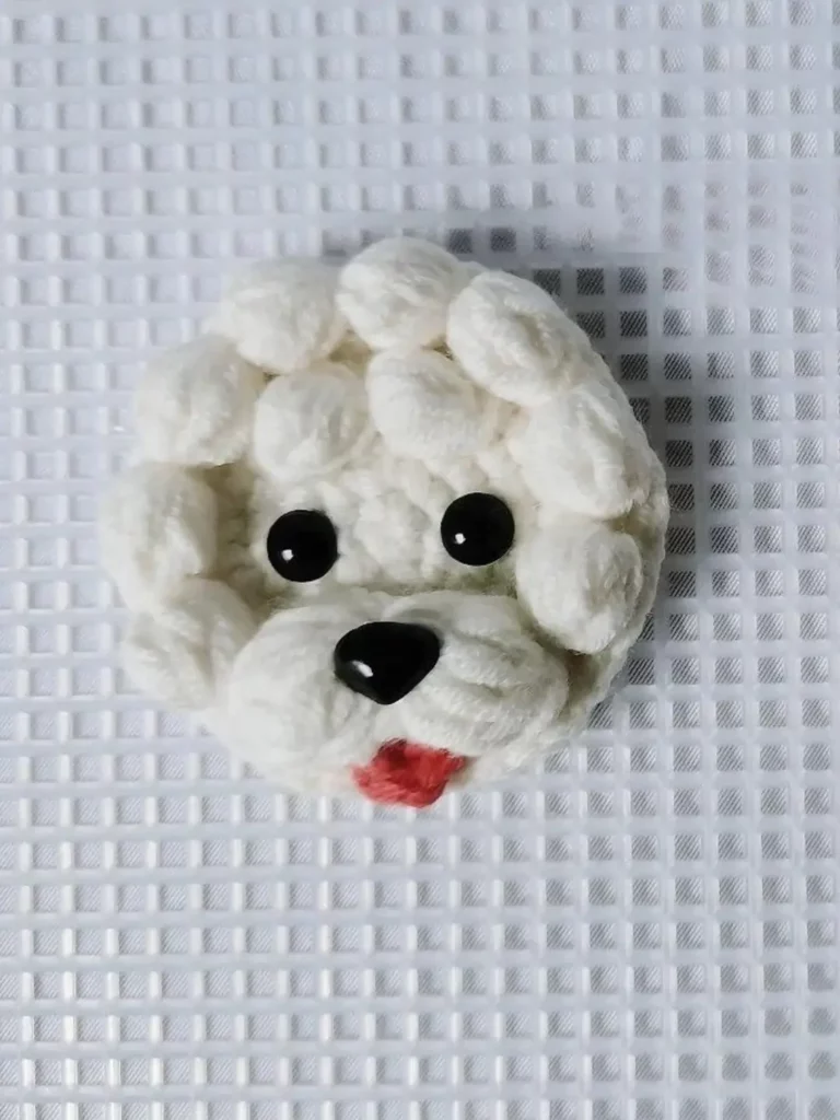 Crocheted white dog head, close-up.