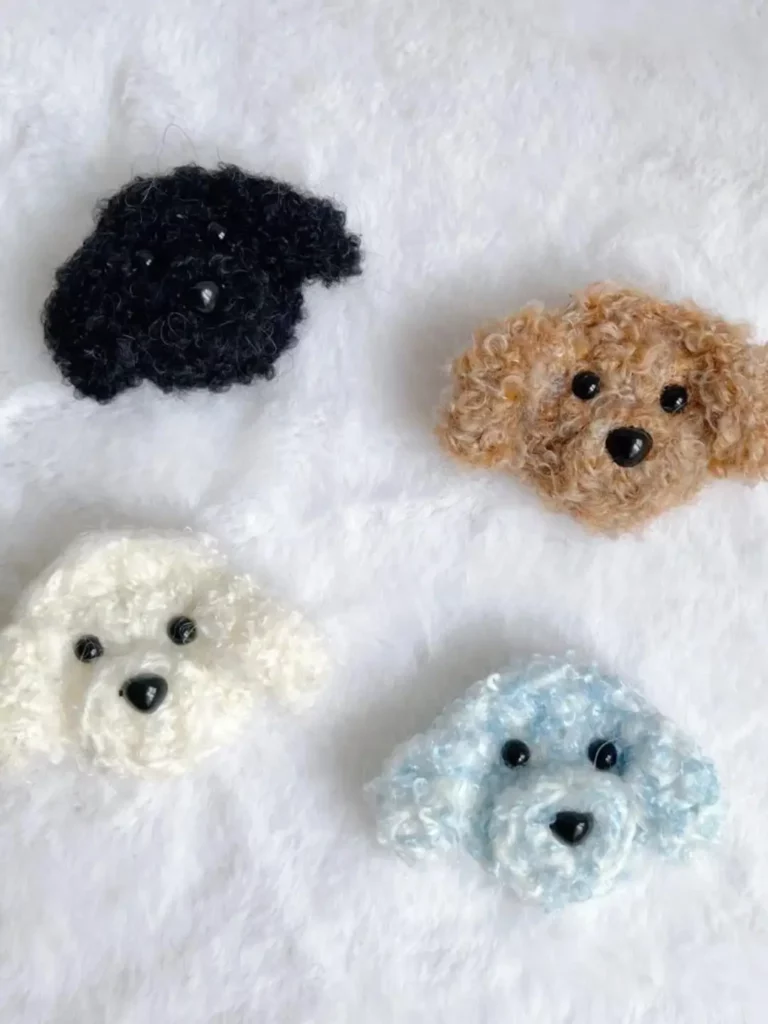 Four crocheted poodle dog head brooches.